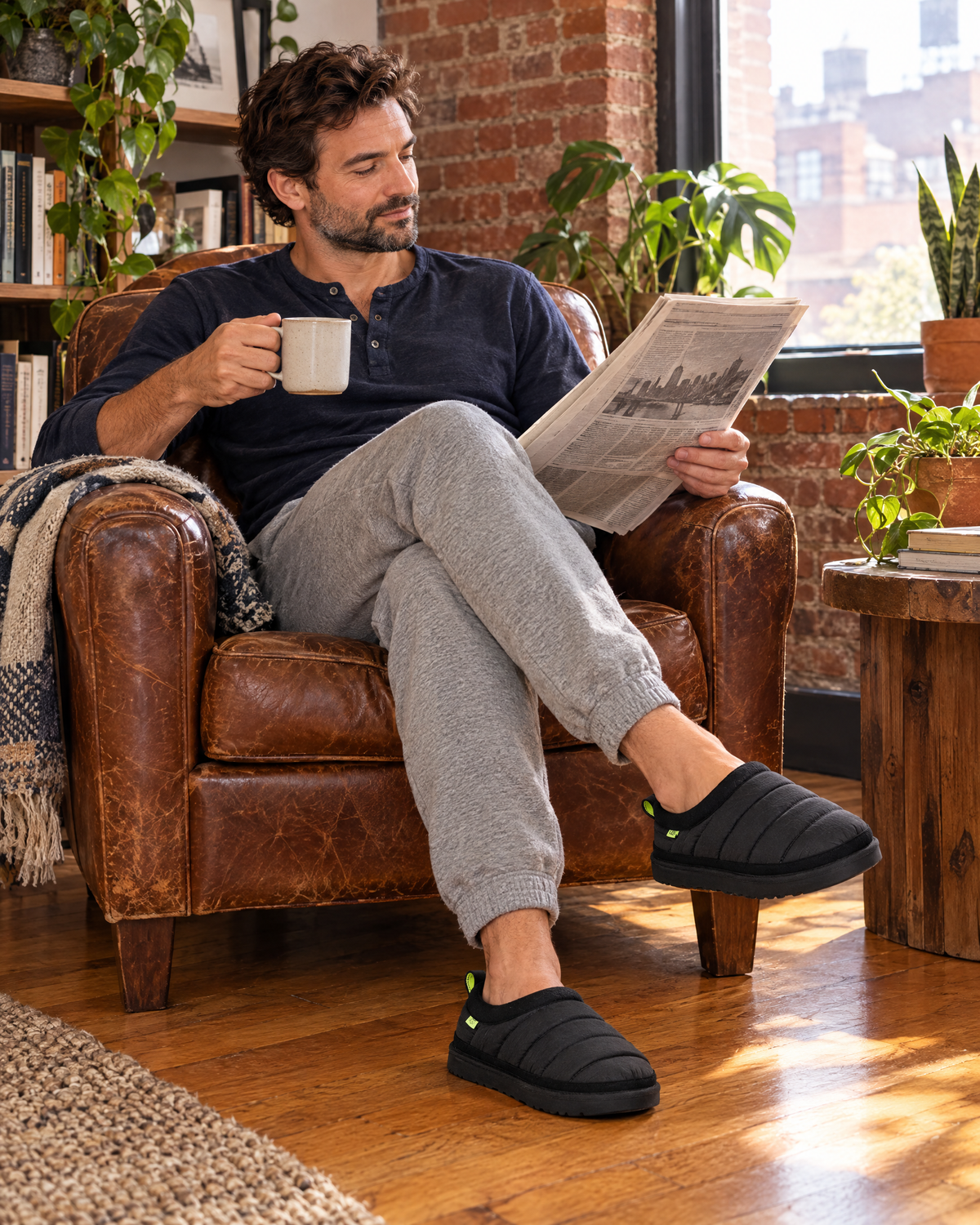 Man relaxing at home in black UGG men's slippers